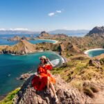 Pemandangan Pulau Padar dari puncak bukit dengan wisatawan duduk menikmati panorama tiga teluk di Taman Nasional Komodo