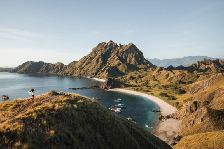 Spot foto terbaik di Pulau Padar dengan panorama bukit savana dan teluk berwarna yang terlihat dari viewpoint puncak