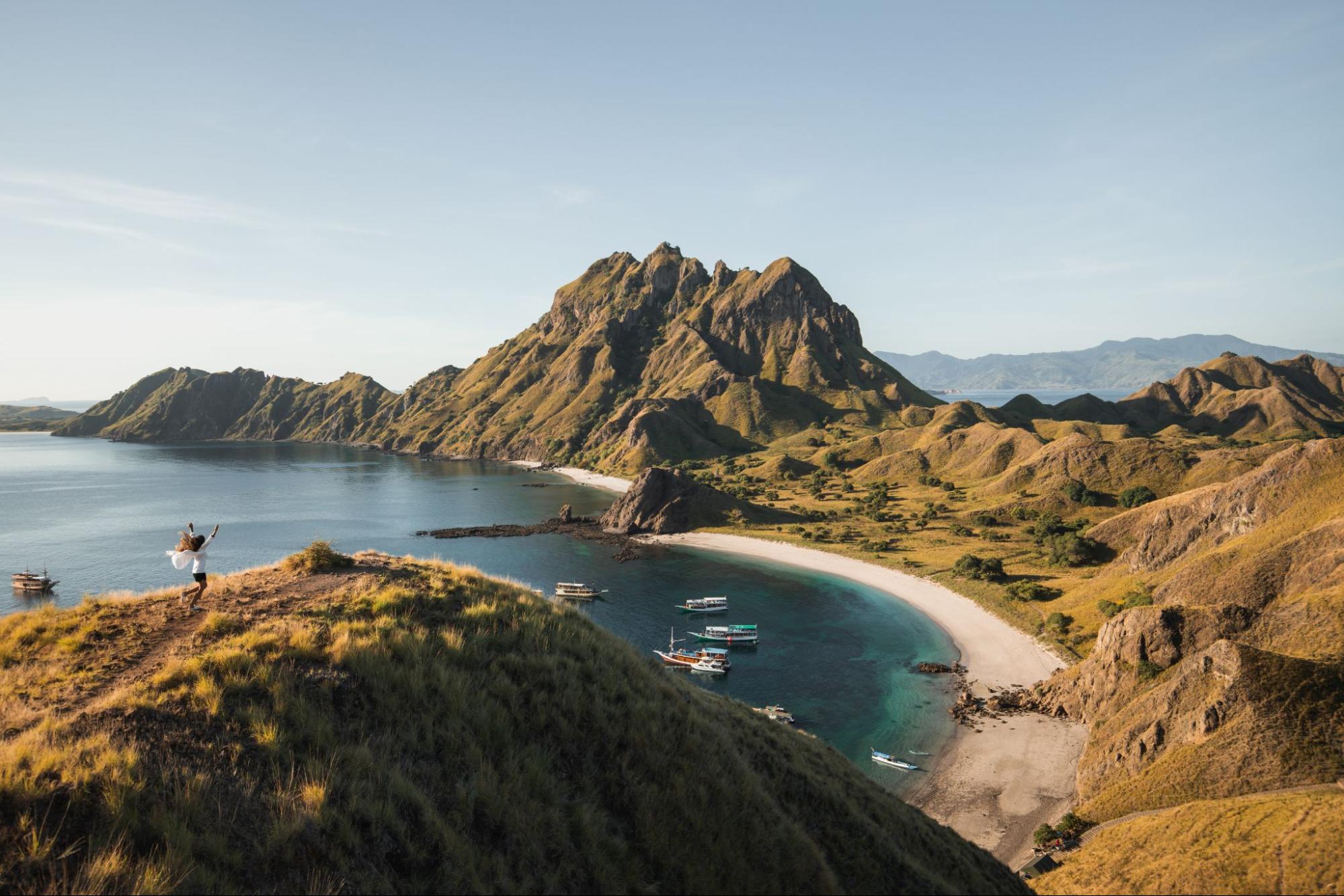 Spot foto terbaik di Pulau Padar dengan panorama bukit savana dan teluk berwarna yang terlihat dari viewpoint puncak