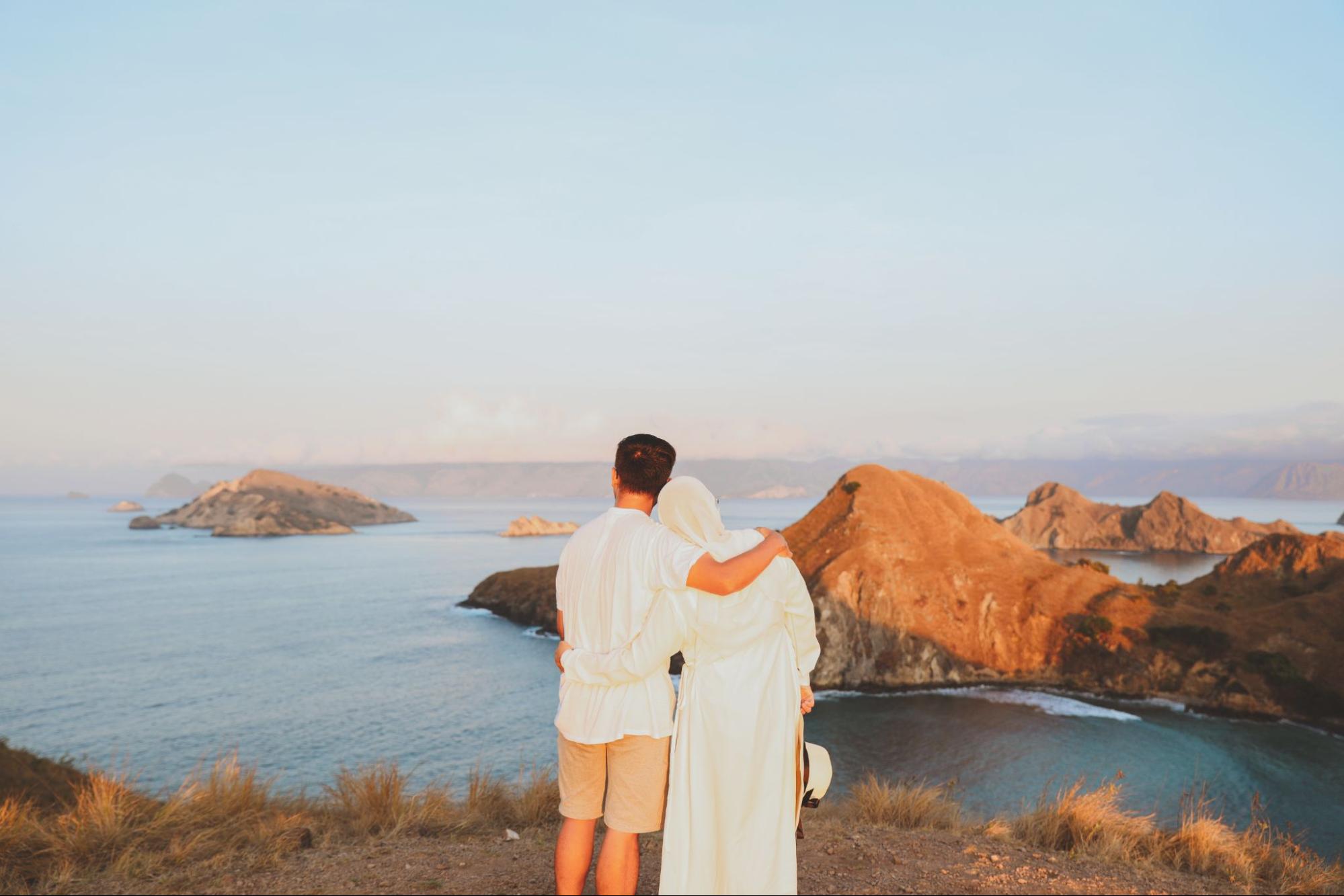 Tips foto dengan HP di Pulau Padar menampilkan panorama laut biru dan perbukitan dari sudut pandang puncak saat cahaya alami lembut